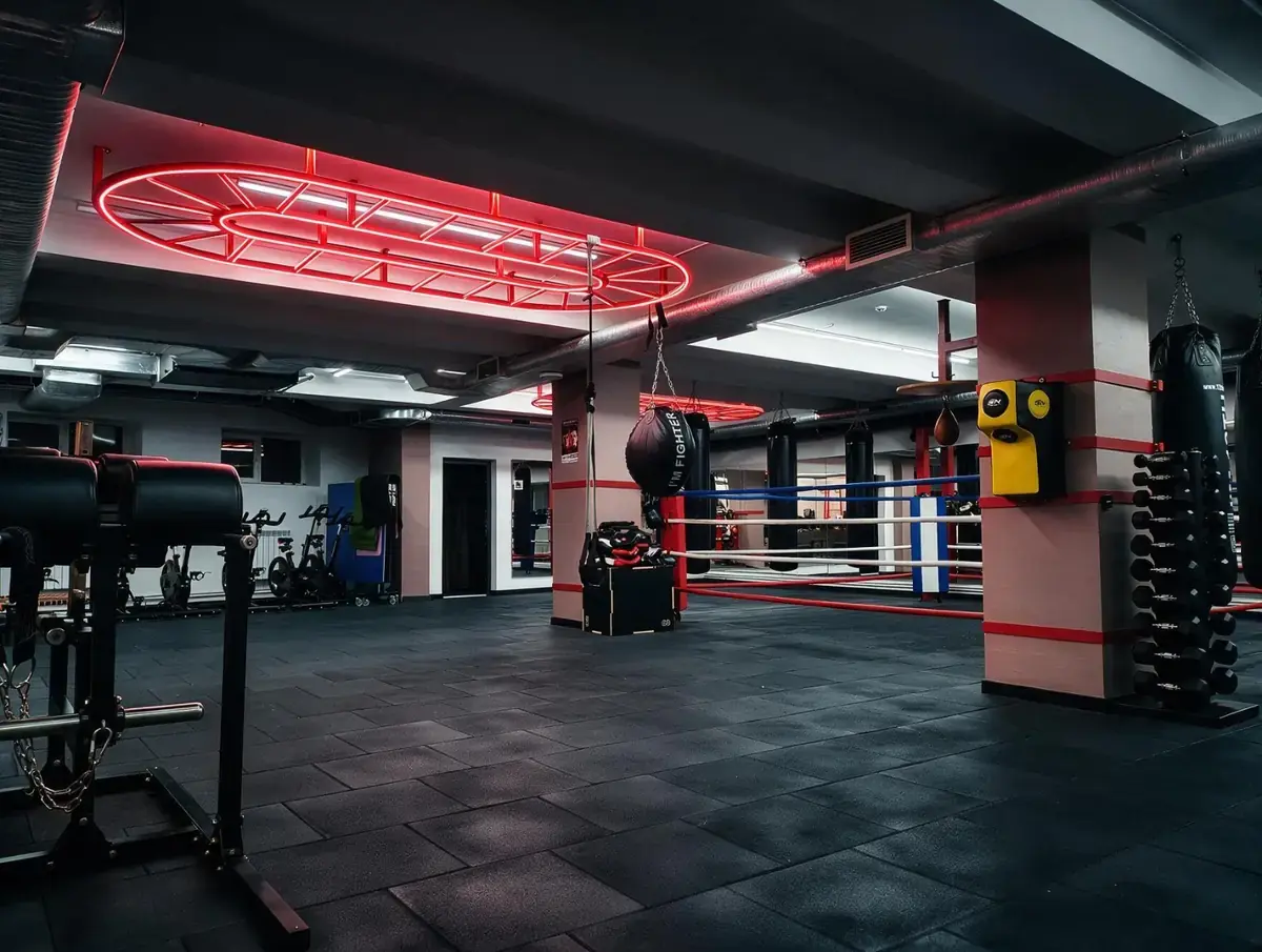 Ring și saci de box în sala Cangur Boxing Club, cu iluminare neon